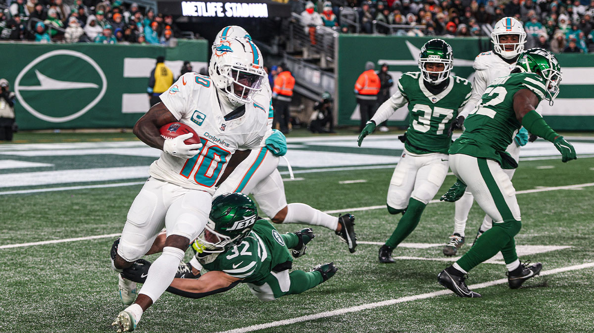 Jan 5, 2025; East Rutherford, New Jersey, USA; Miami Dolphins wide receiver Tyreek Hill (10) is tackled by New York Jets running back Isaiah Davis (32) during a punt return during the first half at MetLife Stadium.