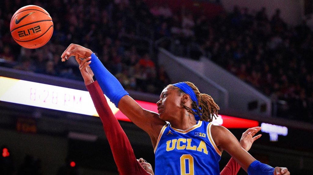UCLA Bruins forward Janiah Barker (0) and USC Trojans guard Kennedy Smith (11) reach for a rebound during an NCAA basketball game.