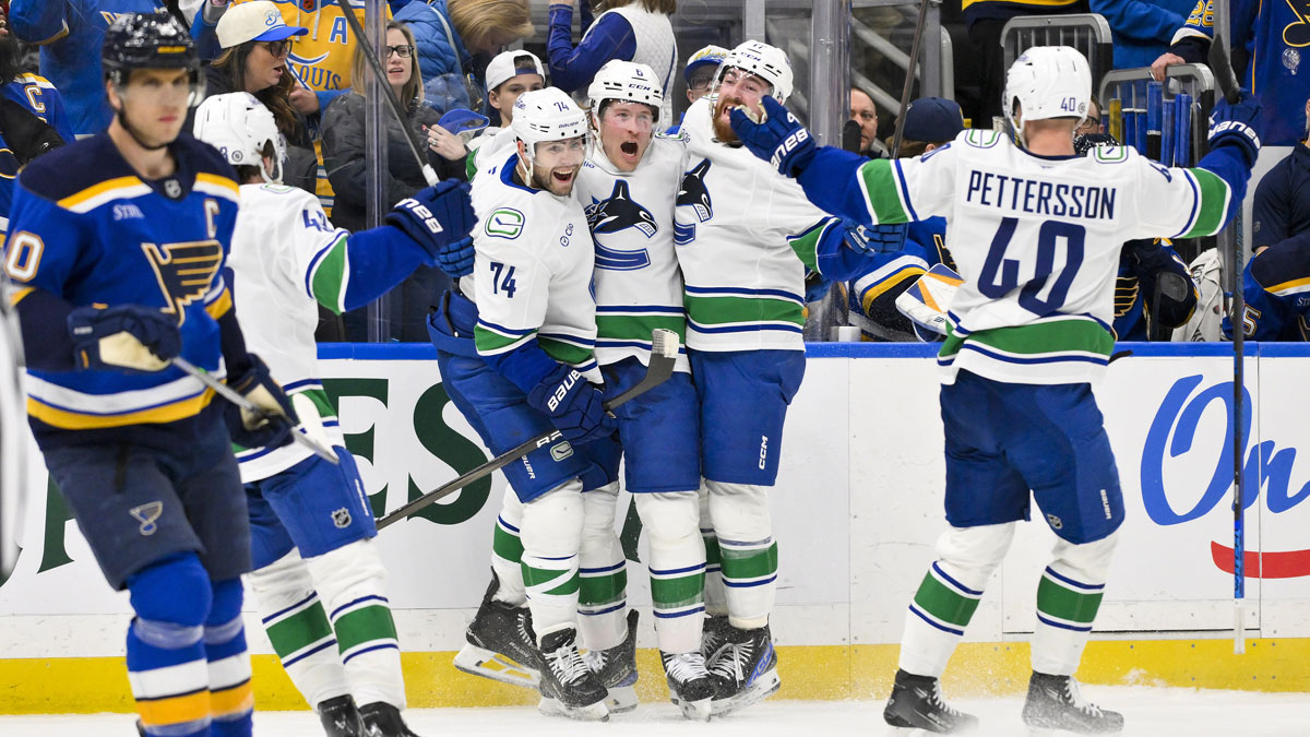 Vancouver Canucks right wing Brock Boeser (6) celebrates with left wing Jake DeBrusk (74) defenseman Filip Hronek (17) and center Elias Pettersson (40) after scoring the game tying goal against the St. Louis Blues during the third period at Enterprise Center.