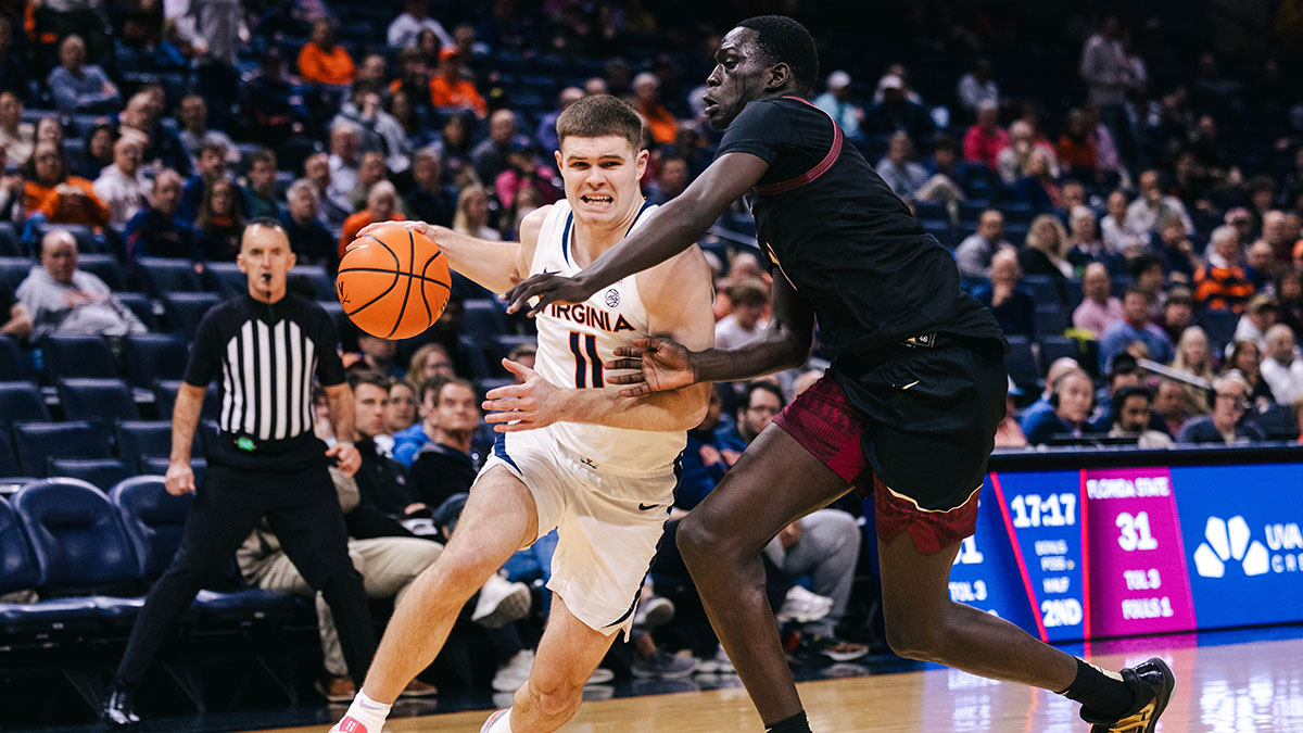 Virginia Cavaliers guard Isaac McKneely (11) dribbles the ball as Florida State Seminoles forward Alier Maluk (21) defends in the second half at John Paul Jones Arena.