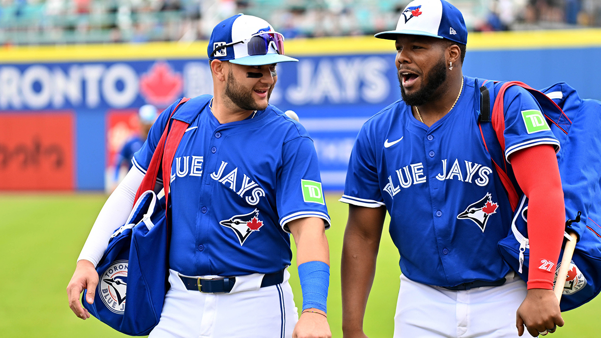 Toronto Blue Jays shortstop Bo Bichette (11) and designated hitter Vladimir Guerrero Jr. (27) walk towards the dugout before a spring training game against the St. Louis Cardinals at TD Ballpark