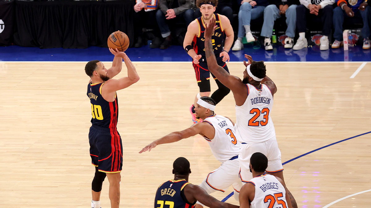 Gold State Warriors Stephen Curri (30) shoots three points in essence of New York Knicks Guard Josh Hart (3) and Mitchell Robinson (23) center in Madison Square Garden.