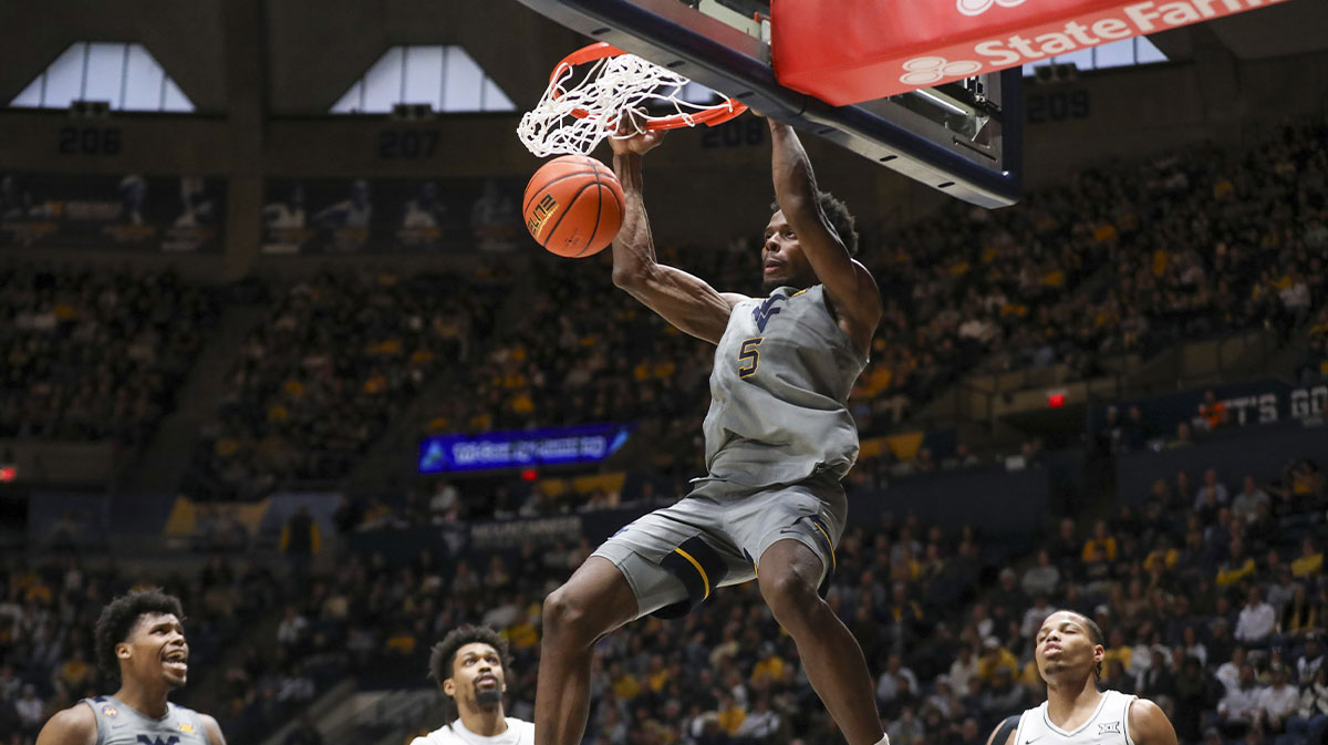West Virginia Mountaineers guard Toby Okani (5) dunks the ball during the first half against the UCF Knights at WVU Coliseum.