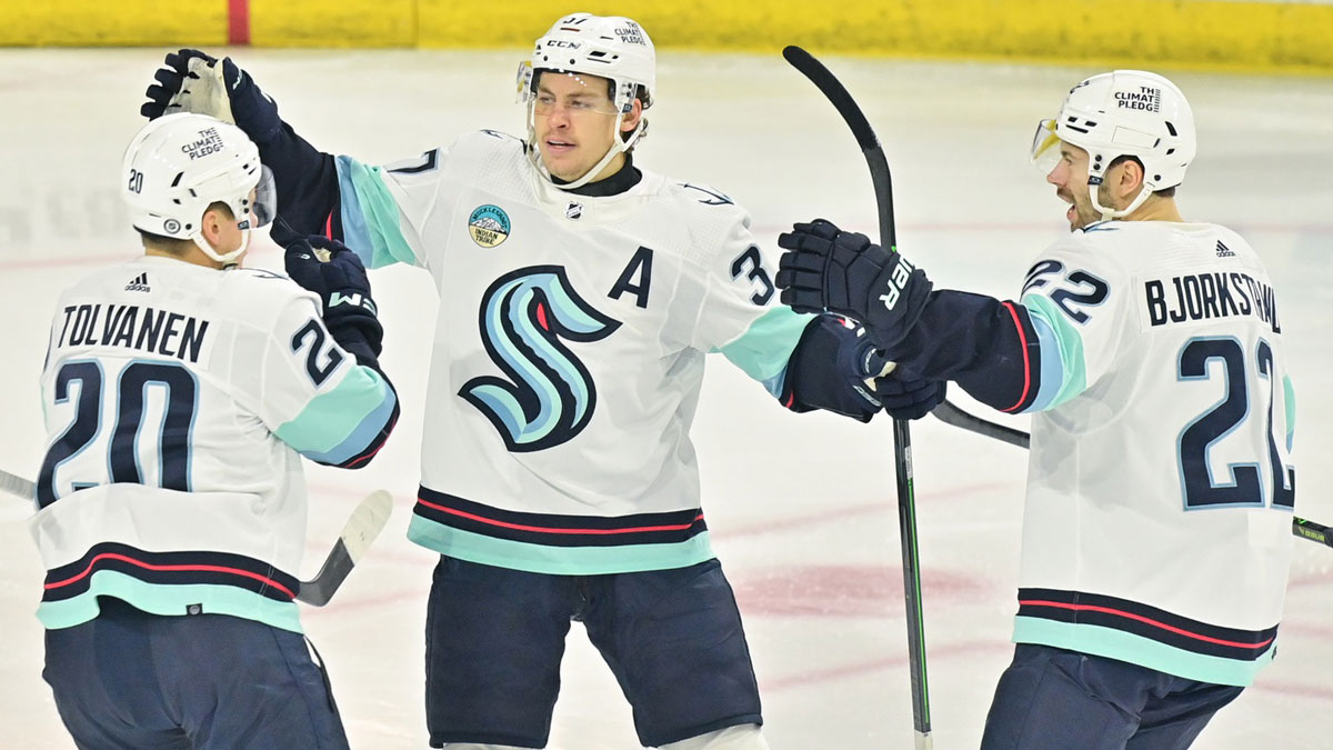 Seattle Kraken right wing Eeli Tolvanen (20) celebrates with center Yanni Gourde (37) and right wing Oliver Bjorkstrand (22) after scoring a goal in the first period against the Arizona Coyotes at Mullett Arena.