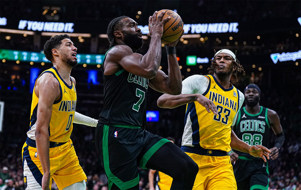 Boston Celtics guard Jaylen Brown (7) drives the ball against Indiana Pacers guard Tyrese Haliburton (0) and center Myles Turner (33) in the second quarter at TD Garden.