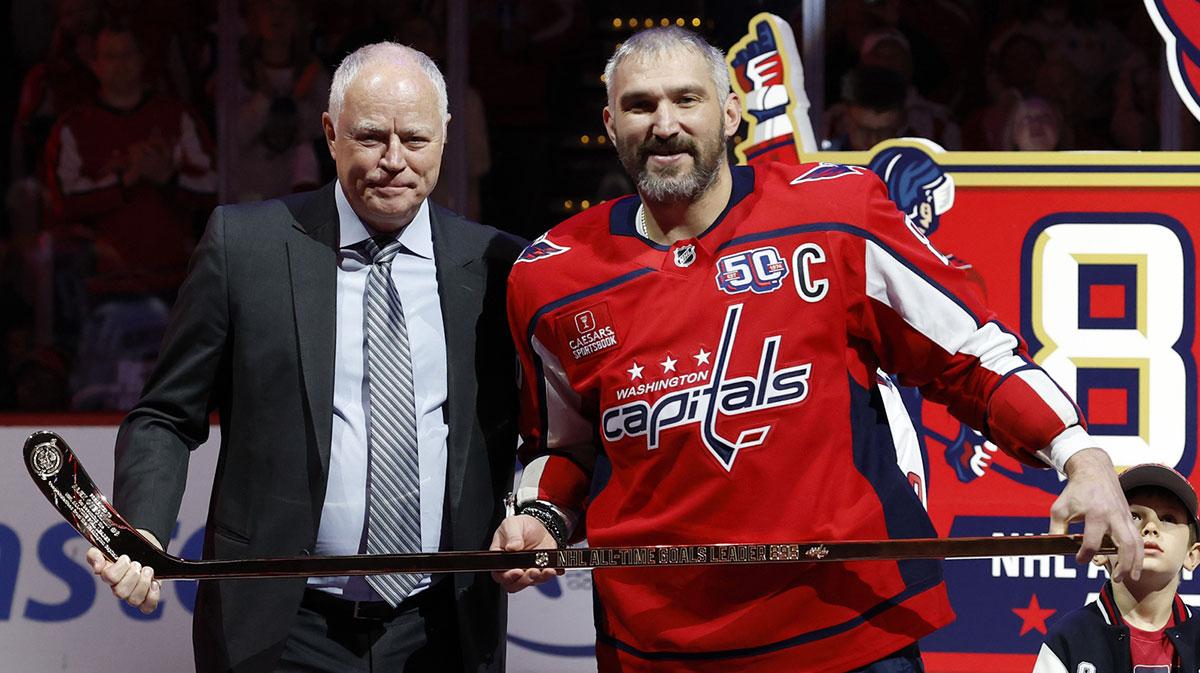 Washington Capitals president of hockey operations Brian McClellan (L) presents Capitals left wing Alex Ovechkin (8) with a gold stick honoring his becoming the NHL all-time goals leader prior to the Capitals' game against the Carolina Hurricanes at Capital One Arena