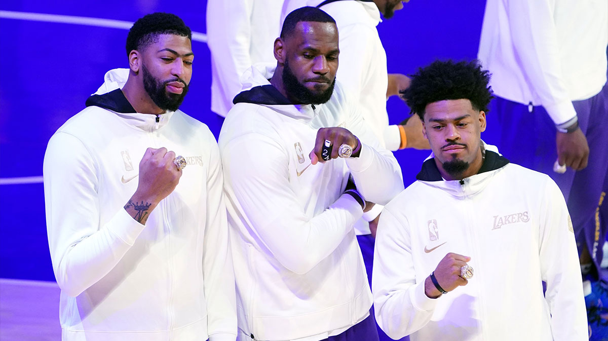 Los Angeles Lakers players Anthony Davis (left) and LeBron James (middle) and Quinn Cook (right) pose with 2020 NBA Championship rings before a game against the Los Angeles Clippers at Staples Center.