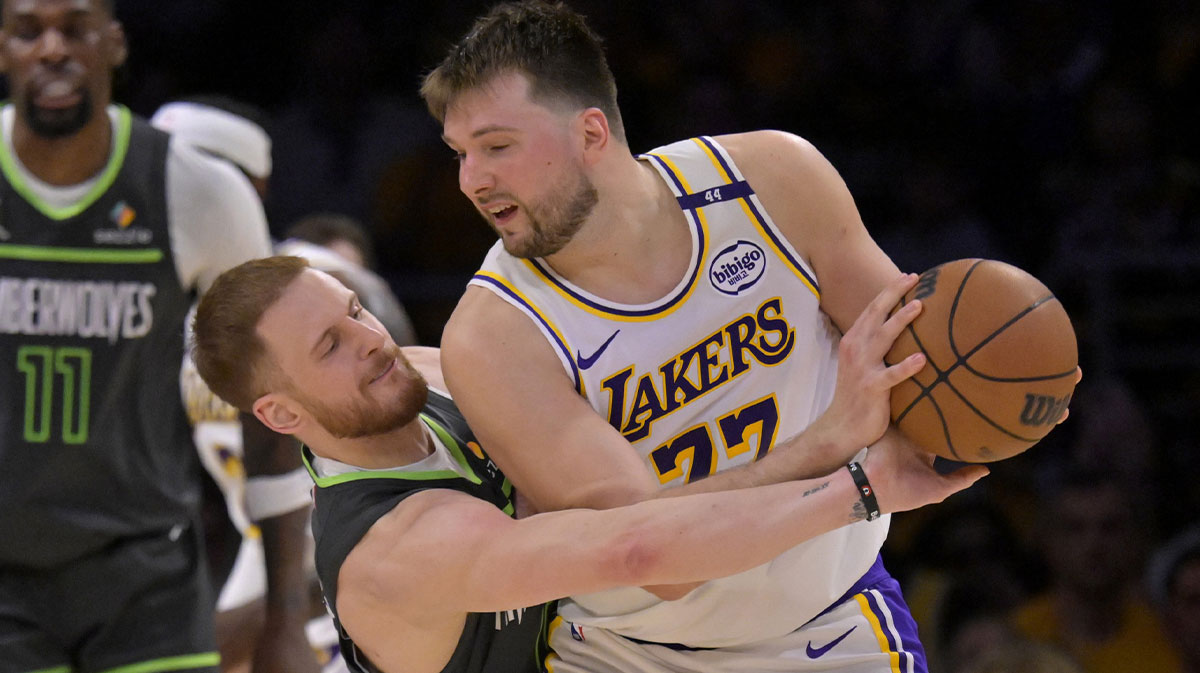 Minnesota Timberwolves guard Donte DiVincenzo (0) reaches in on Los Angeles Lakers guard Luka Doncic (77) in the second half at Crypto.com Arena.