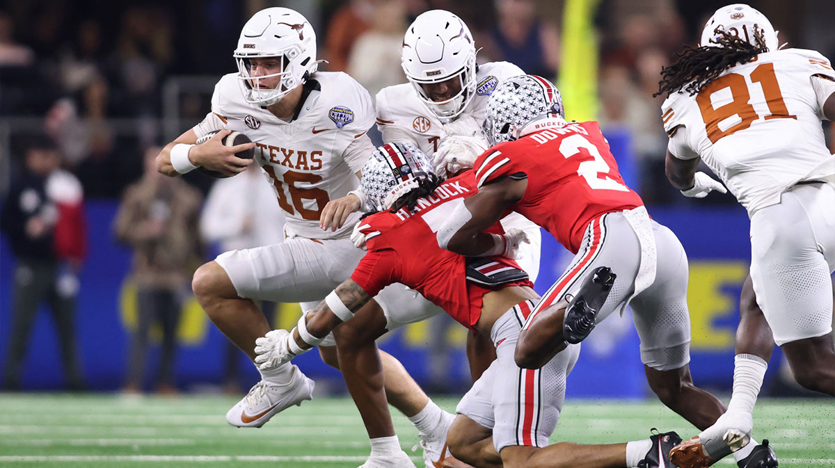 Texas Longhorns quarterback Arch Manning (16) runs against Ohio State Buckeyes cornerback Jordan Hancock (7) and safety Caleb Downs (2) during the second quarter of the College Football Playoff semifinal in the Cotton Bowl at AT&T Stadium.