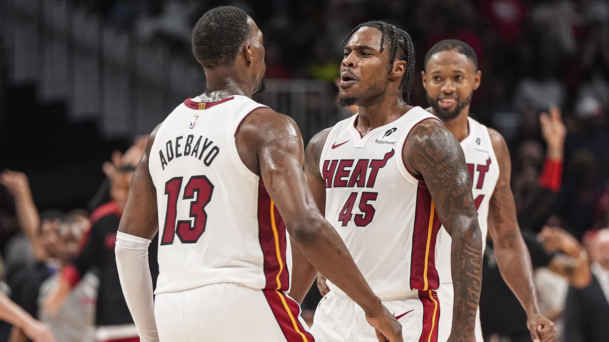 Miami Heat guard Davion Mitchell (45) reacts with center Bam Adebayo (13) after the Heat defeated the Atlanta Hawks in overtime at State Farm Arena.