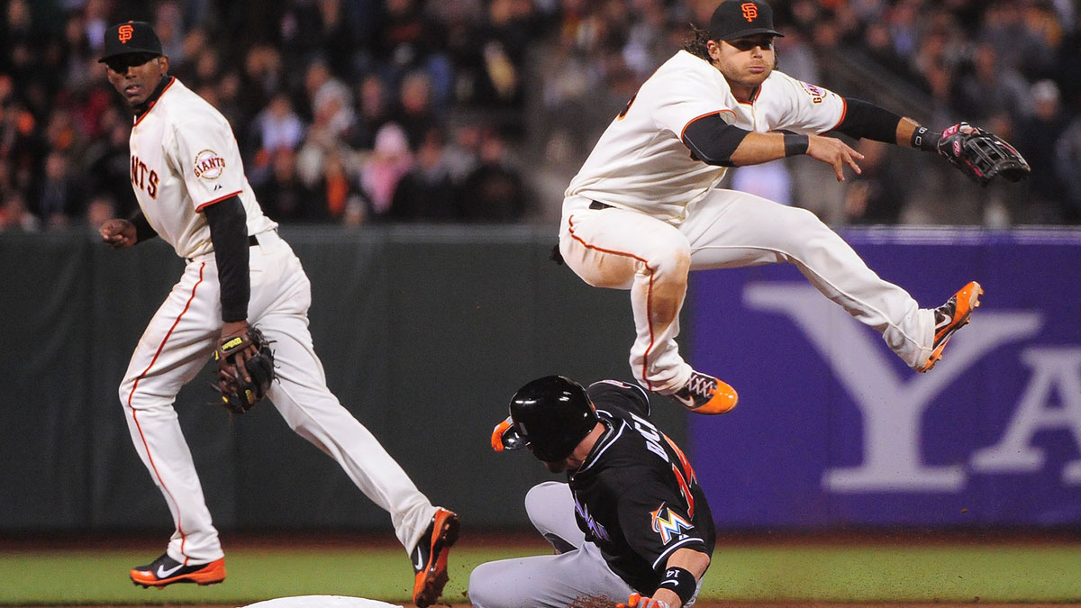 San Francisco Giants shortstop Brandon Crawford (right, top) completes a double play as Miami Marlins catcher John Buck (right, bottom) slides into second base during the fourth inning at AT&T Park.