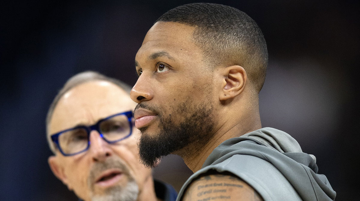 Bucks guard Damian Lillard (right) chats up Warriors assistant coach Ron Adams before a game at Chase Center.