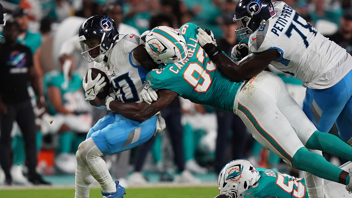 Sep 30, 2024; Miami Gardens, Florida, USA; Miami Dolphins defensive tackle Calais Campbell (93) tackles Tennessee Titans running back Tony Pollard (20) during the first half at Hard Rock Stadium.