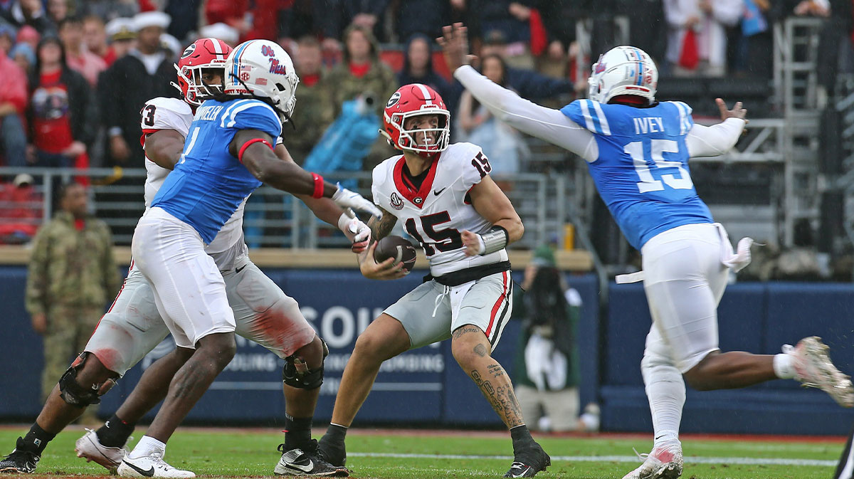 Georgia Bulldogs quarterback Carson Beck (15) drops back to pass as Mississippi (Ole Miss) Rebels defensive Jared Ivey (15) rushes during the first half at Vaught-Hemingway Stadium.