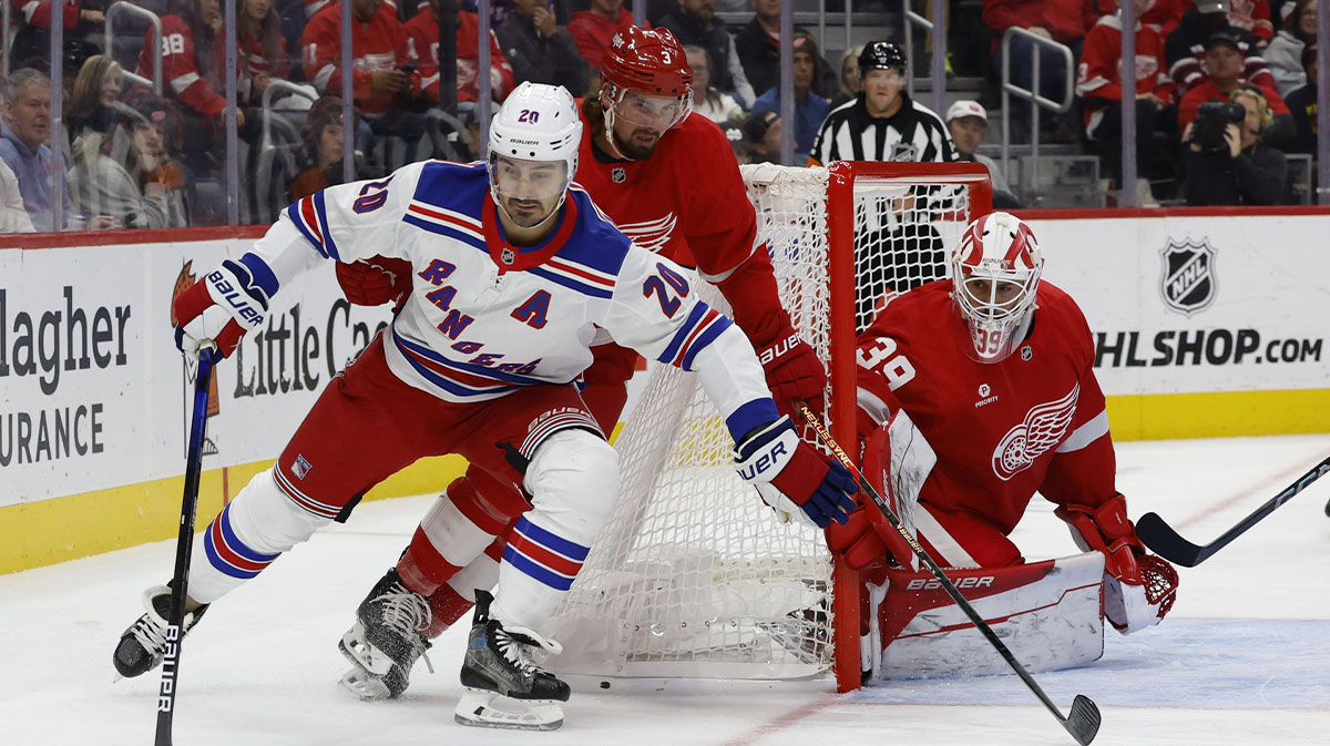New York Rangers left wing Chris Kreider (20) skates with the puck chased by Detroit Red Wings defenseman Justin Holl (3) in the first period at Little Caesars Arena.