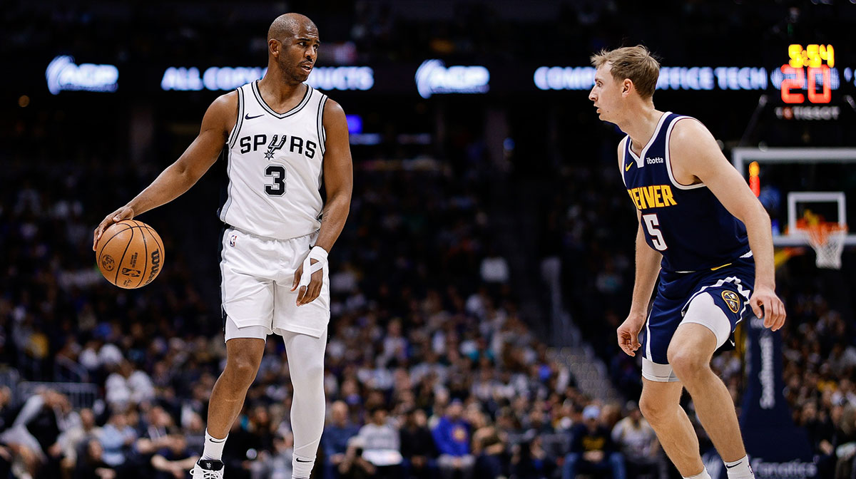 San Antonio Spurs guard Chris Paul (3) controls the ball as Denver Nuggets forward Hunter Tyson (5) guards in the first quarter at Ball Arena.