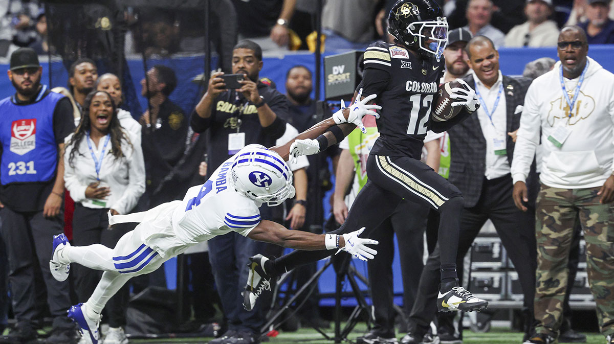 Colorado Buffaloes wide receiver Travis Hunter (12) runs with the ball as Brigham Young Cougars cornerback Mory Bamba (4) attempts to make a tackle during the second quarter at Alamodome.