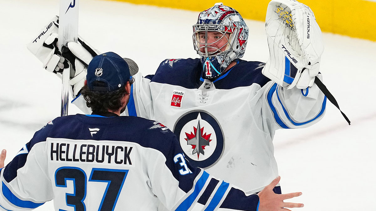 Winnipeg Jets goaltender Eric Comrie (1) celebrates with Winnipeg Jets goaltender Connor Hellebuyck (37) after shutting out the Vegas Golden Knights 4-0 at T-Mobile Arena.