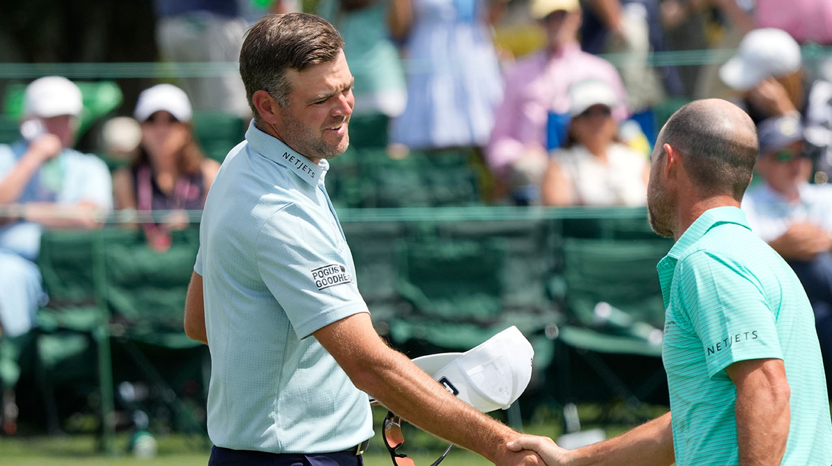 Corey Conners shakes hands with Brian Harman on the eighteenth green during the first round of the Masters Tournament.