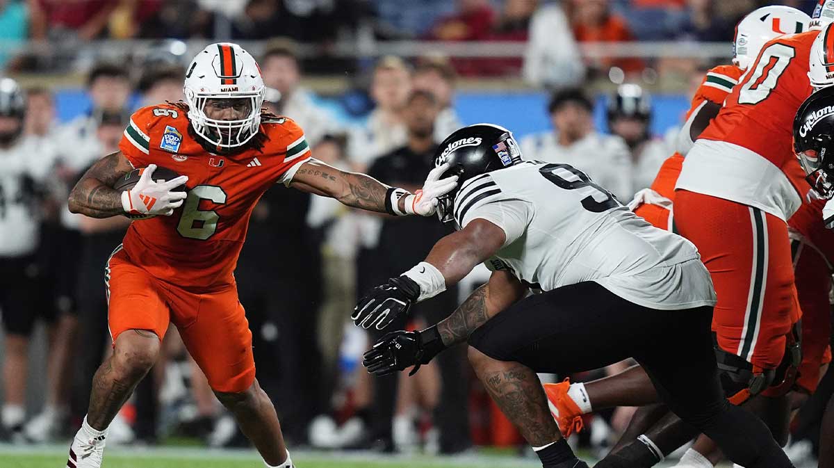 Miami Hurricanes running back Damien Martinez (6) stiff arms Iowa State Cyclones linebacker Cael Brezina (9) during the second half at Camping World Stadium. Mandatory Credit: Jasen Vinlove-Imagn Images