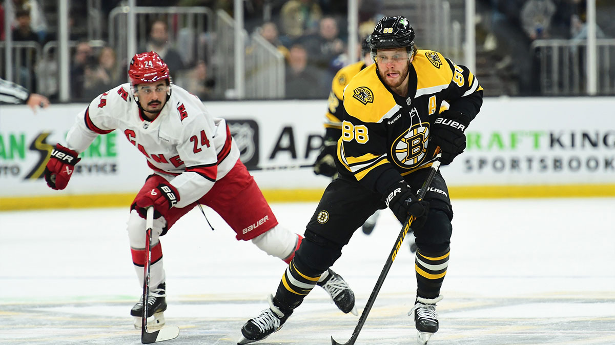 Boston Bruins right wing David Pastrnak (88) skates the puck ahead of Carolina Hurricanes center Seth Jarvis (24) during the first period at TD Garden