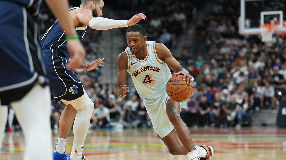 San Antonio Spurs guard De'Aaron Fox (4) dribbles against Dallas Mavericks forward Caleb Martin (16) in the first half at Frost Bank Center.