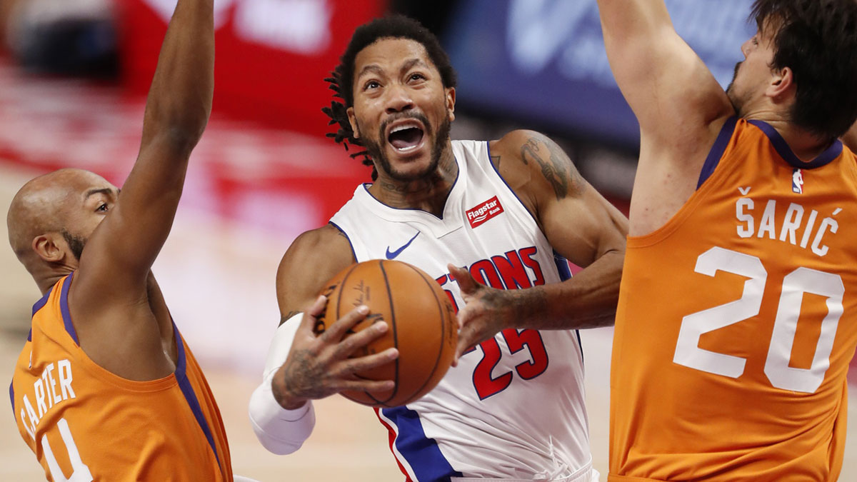 Detroit Pistons guard Derrick Rose (25) goes up for a shot against Phoenix Suns guard Jevon Carter (4) and forward Dario Saric (20) during the second quarter at Little Caesars Arena.