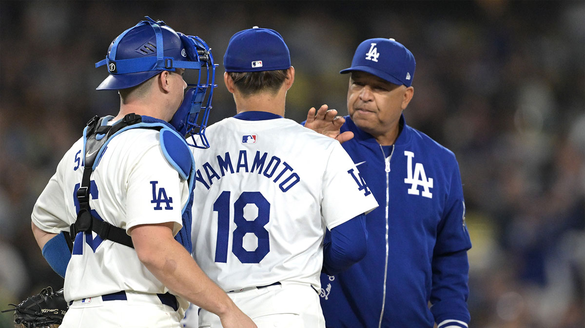Los Angeles Dodgers catcher Will Smith (16) looks on as manager Dave Roberts (30) pulls starting pitcher Yoshinobu Yamamoto (18) in the seventh inning against the Arizona Diamondbacks at Dodger Stadium.