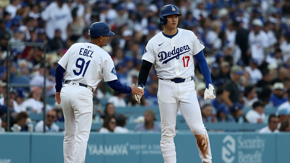 Los Angeles Dodgers designated hitter Shohei Ohtani (17) reacts after getting on base with third base coach/outfield coach Dino Ebel (91) during he first inning against the Chicago Cubs at Dodger Stadium.