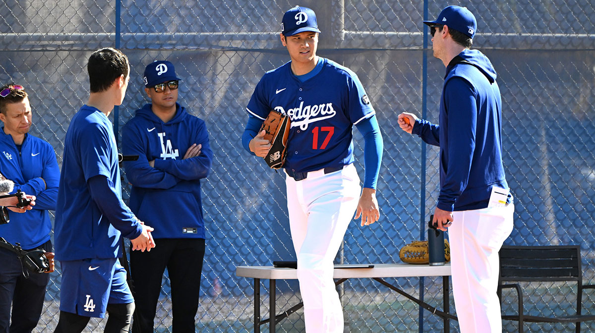 Los Angeles Dodgers designated hitter Shohei Ohtani (17) works with Los Angeles Dodgers assistant pitching coach Connor McGuiness (87) during a spring training bullpen session at Camelback Ranch.