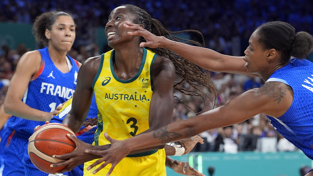 Australia forward Ezi Magbegor (13) controls the ball against France centre Dominique Malonga (14) and small forward Valeriane Ayayi (11) in the second half in a women’s group B game during the Paris 2024 Olympic Summer Games at Stade Pierre-Mauroy.