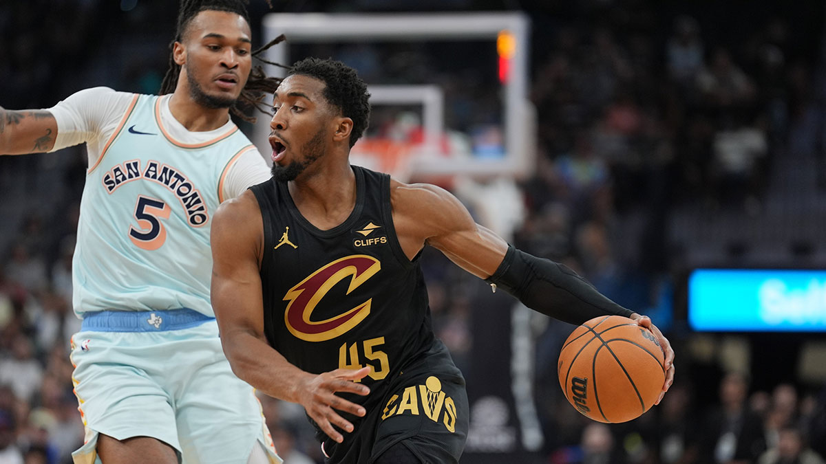 Cleveland Cavaliers guard Donovan Mitchell (45) dribbles past San Antonio Spurs guard Stephon Castle (5) in the first half at Frost Bank Center.