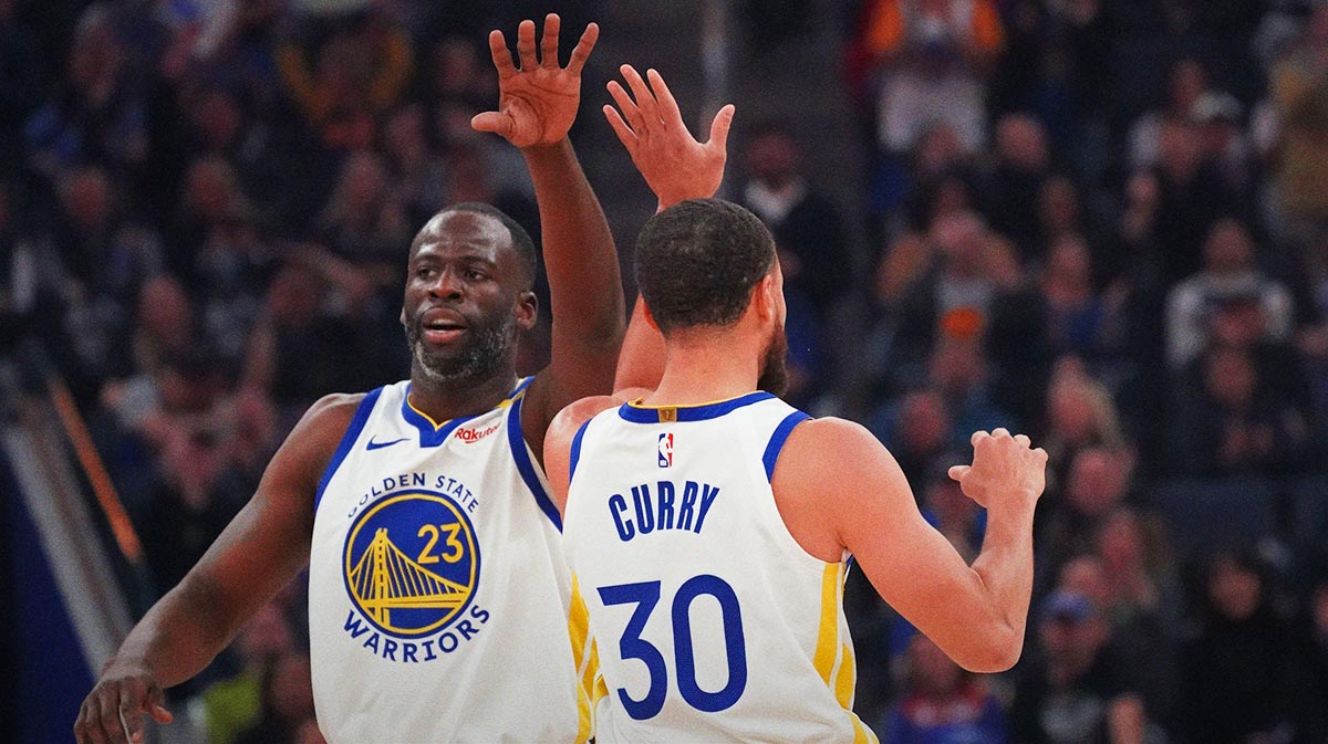 Golden State Warriors forward Draymond Green (23) and guard Stephen Curry (30) high-five during the first quarter against the Detroit Pistons at Chase Center.