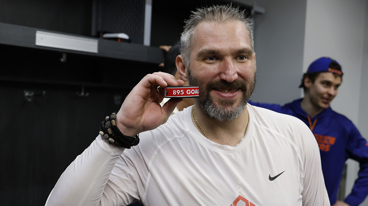 Washington Capitals left wing Alex Ovechkin (8) poses with the puck as he celebrates after scoring a goal in the 2nd period against the New York Islanders at UBS Arena. The goal is the 895th of Ovechkin’s career, breaking the NHL all-time career goals record previously held by Wayne Gretzky at UBS Arena.