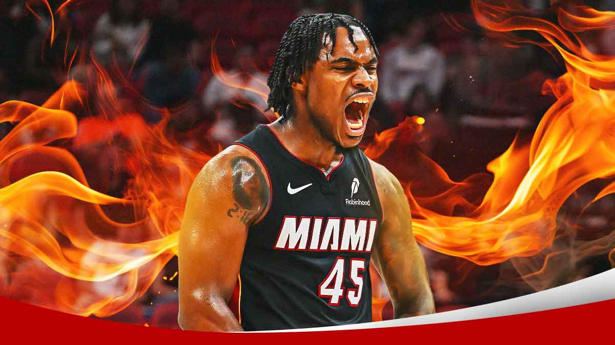 Miami Heat star Davion Mitchell with fire around him in front of Kaseya Center.