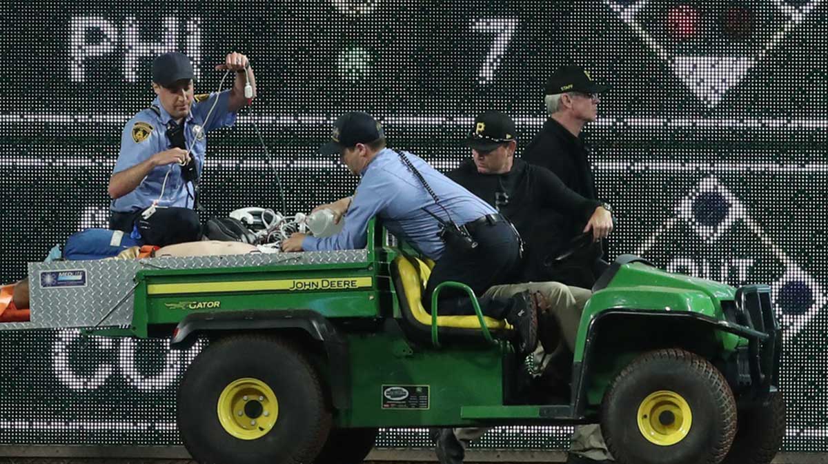 Stadium security and Pittsburgh Pirates medical personnel cart a fan who fell from the stands to the field to an ambulance as the Pirates batted against the Chicago Cubs during the seventh inningat PNC Park
