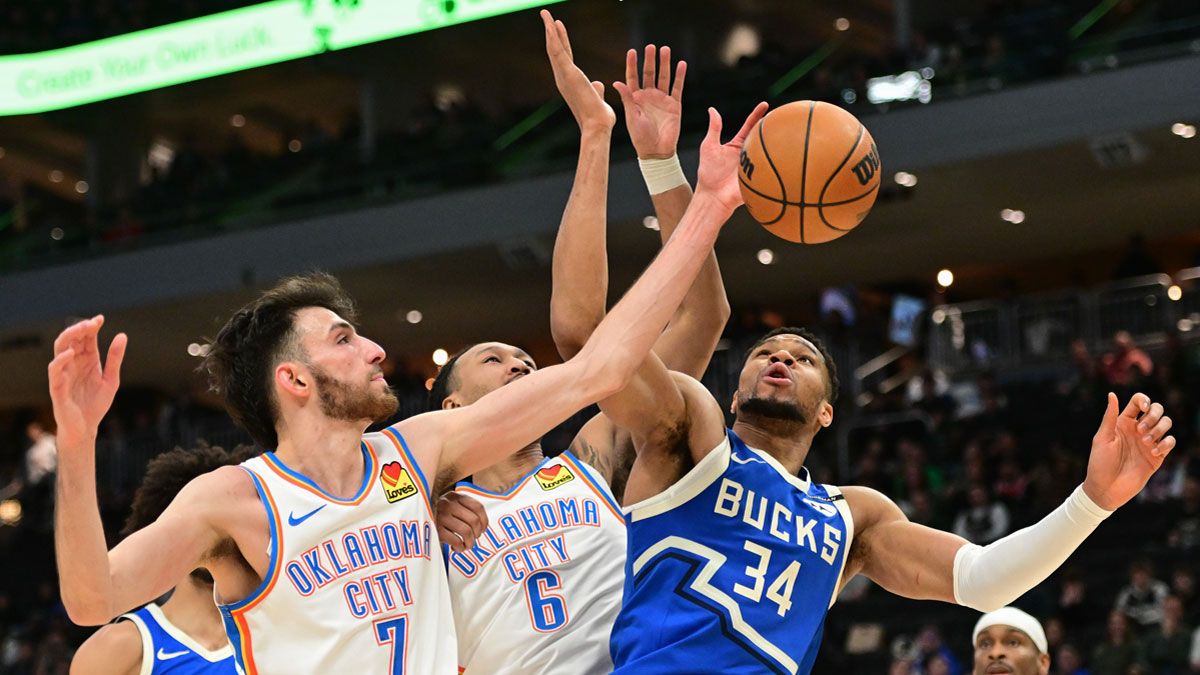 Milwaukee Bucks forward Giannis Antetokounmpo (34) reaches for the ball against Oklahoma City Thunder center Chet Holmgren (7) and forward Jaylin Williams (6) in the fourth quarter at Fiserv Forum.