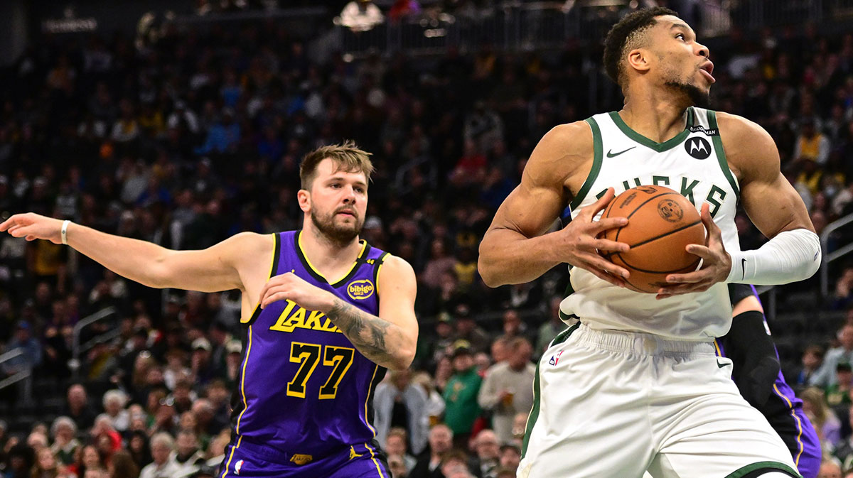 Milwaukee Bucks forward Giannis Antetokounmpo (34) controls the ball against Los Angeles Lakers guard Luka Doncic (77) in the first quarter at Fiserv Forum.