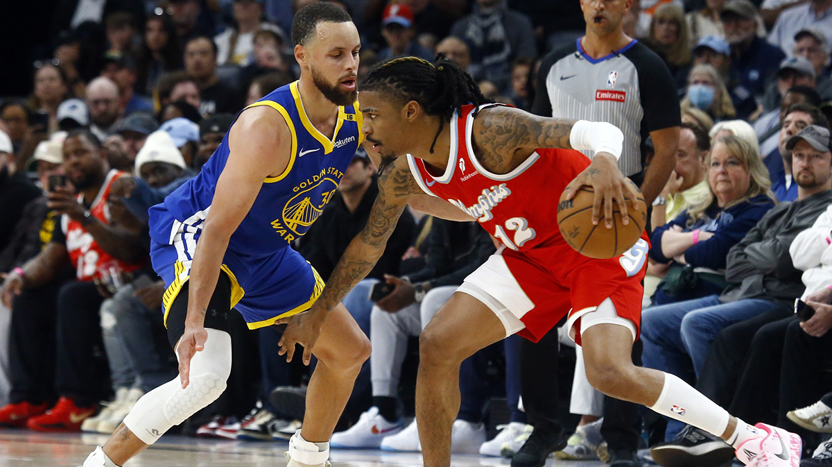 Memphis Grizzlies guard Ja Morant (12) dribbles as Golden State Warriors guard Stephen Curry (30) defends during the fourth quarter at FedExForum