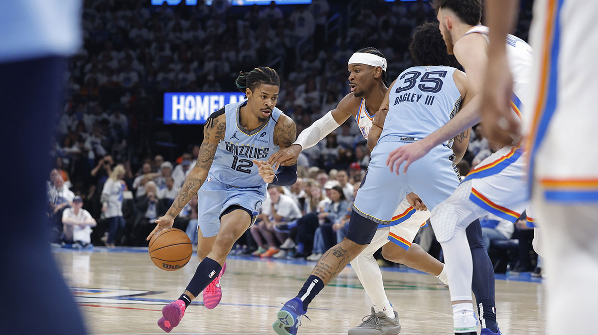 Memphis Grizzlies guard Ja Morant (12) dribbles around Oklahoma City Thunder guard Shai Gilgeous-Alexander (2) during the second half at Paycom Center. Mandatory Credit: Alonzo Adams-Imagn Imag