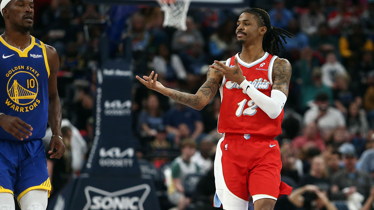 Grizzlies guard Ja Morant with the Grizzlies logo in the background with Grizzlies grenade celebration