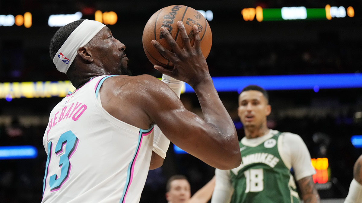 Miami Heat center Bam Adebayo (13) takes a shot as Milwaukee Bucks forward Kyle Kuzma (18) closes in during the first half at Kaseya Center.