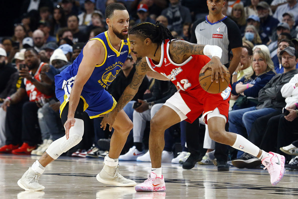 Memphis Grizzlies guard Ja Morant (12) dribbles as Golden State Warriors guard Stephen Curry (30) defends during the fourth quarter at FedExForum.