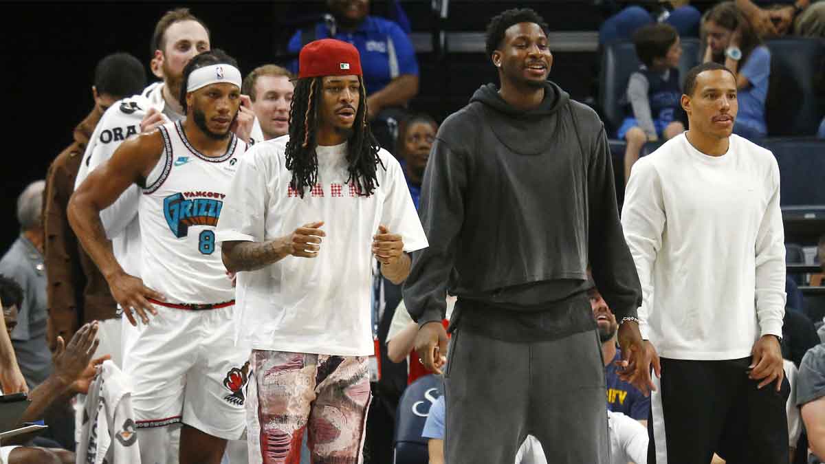 Memphis Grizzlies guard Ja Morant (left), forward Jaren Jackson Jr. (middle) and guard Desmond Bane (22) look on from the bench area during the second quarter against the Dallas Mavericks at FedExForum.