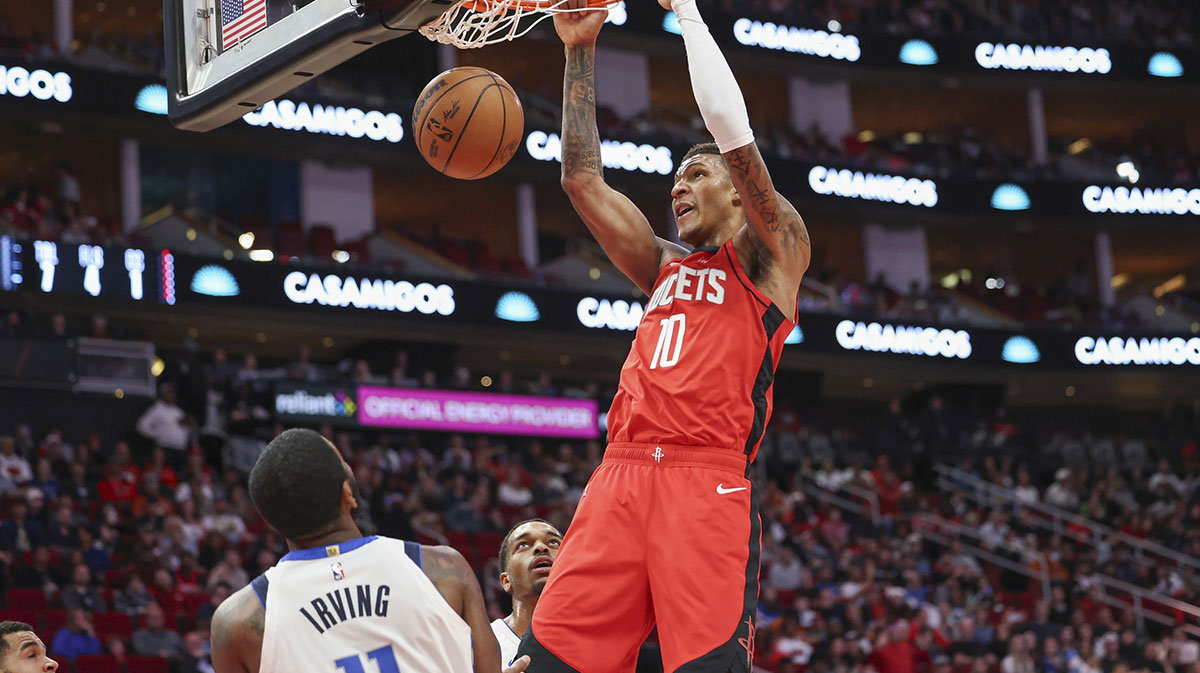 Houston Rockets forward Jabari Smith Jr. (10) dunks the ball as Dallas Mavericks guard Kyrie Irving (11) defends during the first quarter at Toyota Center.