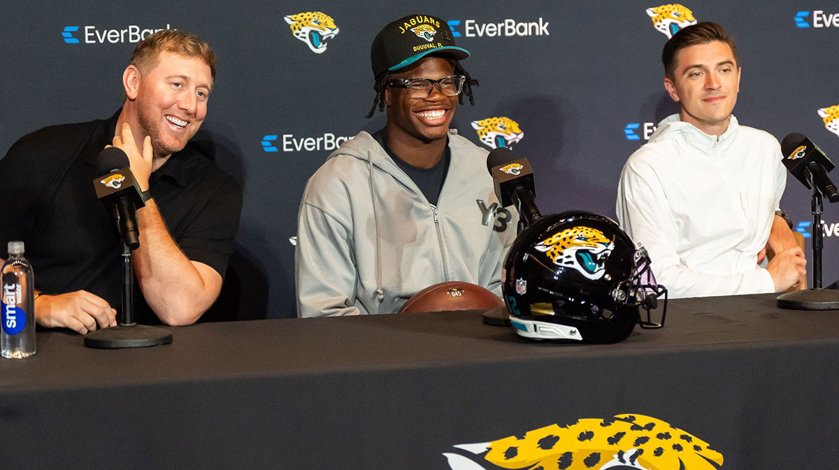 Jacksonville Jaguars ead Coach Liam Coen, left, has a laugh with Jacksonville Jaguars’ first-round pick, Colorado Buffaloes wide receiver and defensive back Travis Hunter, center, during a press conference