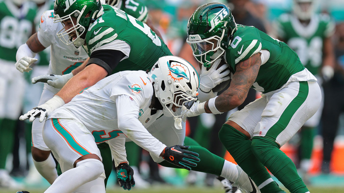New York Jets running back Braelon Allen (0) runs with the football as Miami Dolphins cornerback Jalen Ramsey (5) attempts a tackle during the third quarter at Hard Rock Stadium. Mandatory Credit: Sam Navarro-Imagn Images