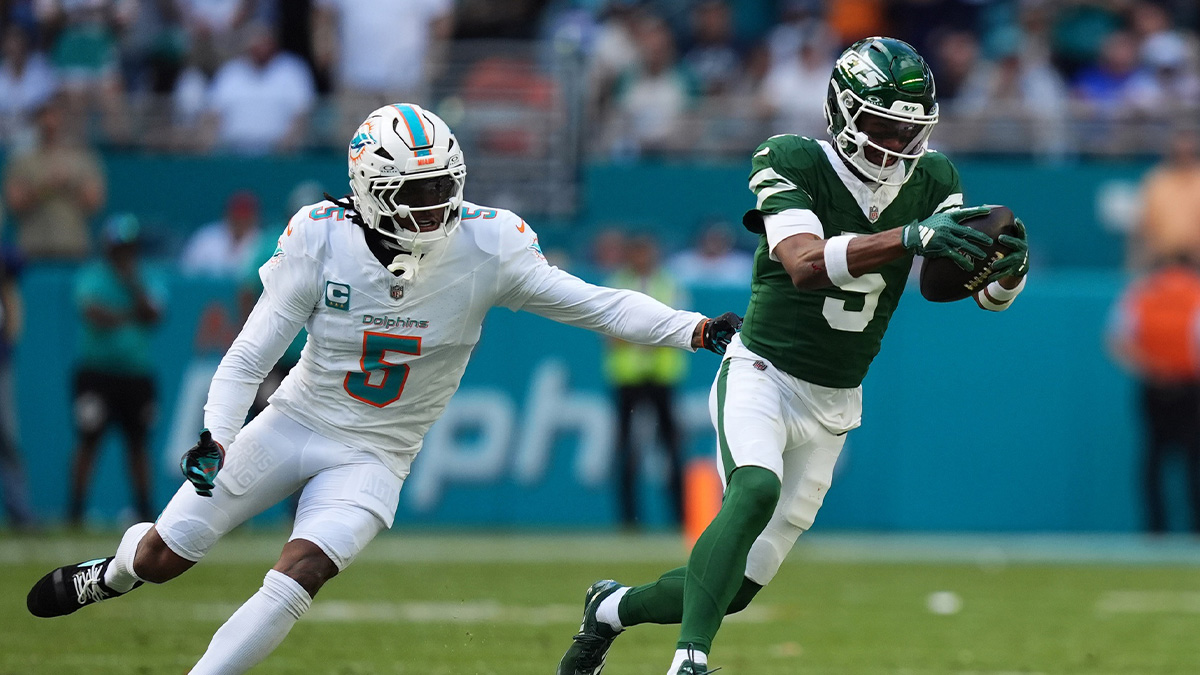 New York Jets wide receiver Garrett Wilson (5) runs with the ball away from Miami Dolphins cornerback Jalen Ramsey (5) during the first half at Hard Rock Stadium.