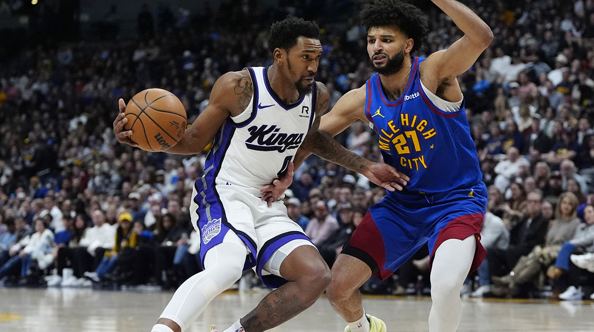 Sacramento Kings guard Malik Monk (0) drives at Denver Nuggets guard Jamal Murray (27) in the second half at Ball Arena.