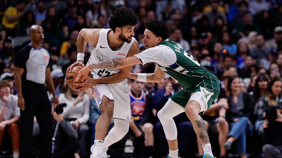 Denver Nuggets guard Jamal Murray (27) controls the ball under pressure from Milwaukee Bucks guard Ryan Rollins (13) in the fourth quarter at Ball Arena.